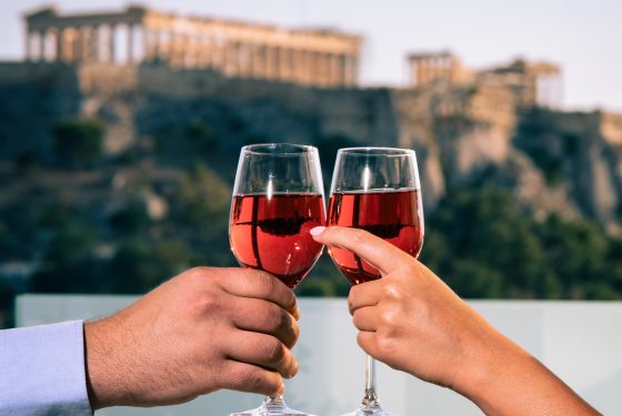 Couple toasting with rose wine with a view of the Acropolis